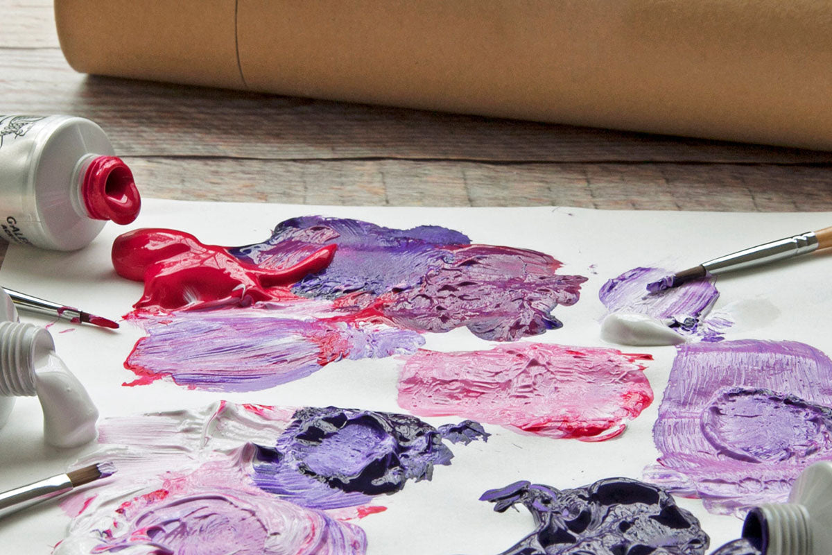 Blobs of purple red and white paint mixed together on paper
