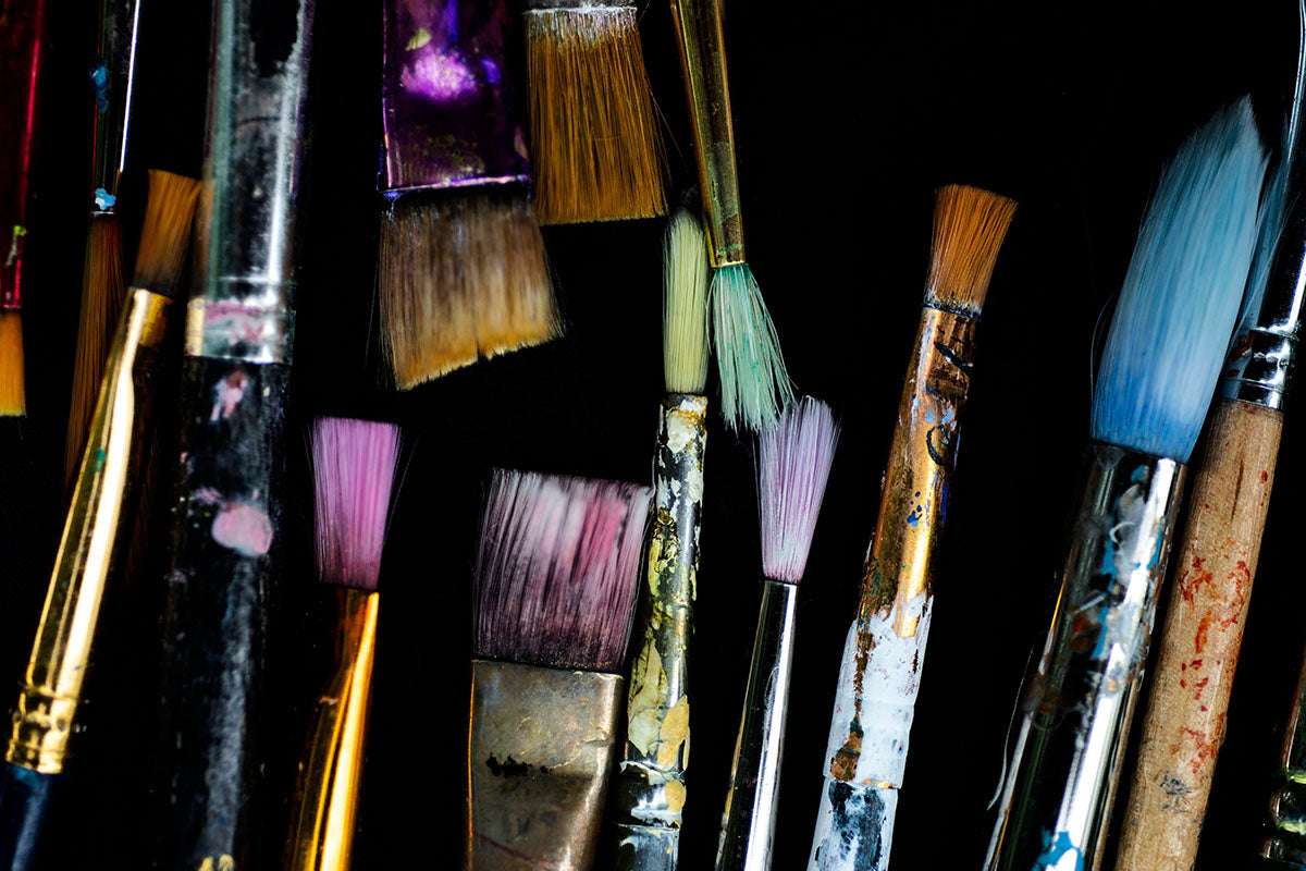Dyed Paint Brushes Laying On Black Surface