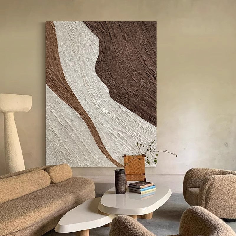Wabi-sabi style living room with paintings on the wall next to the sofa and table